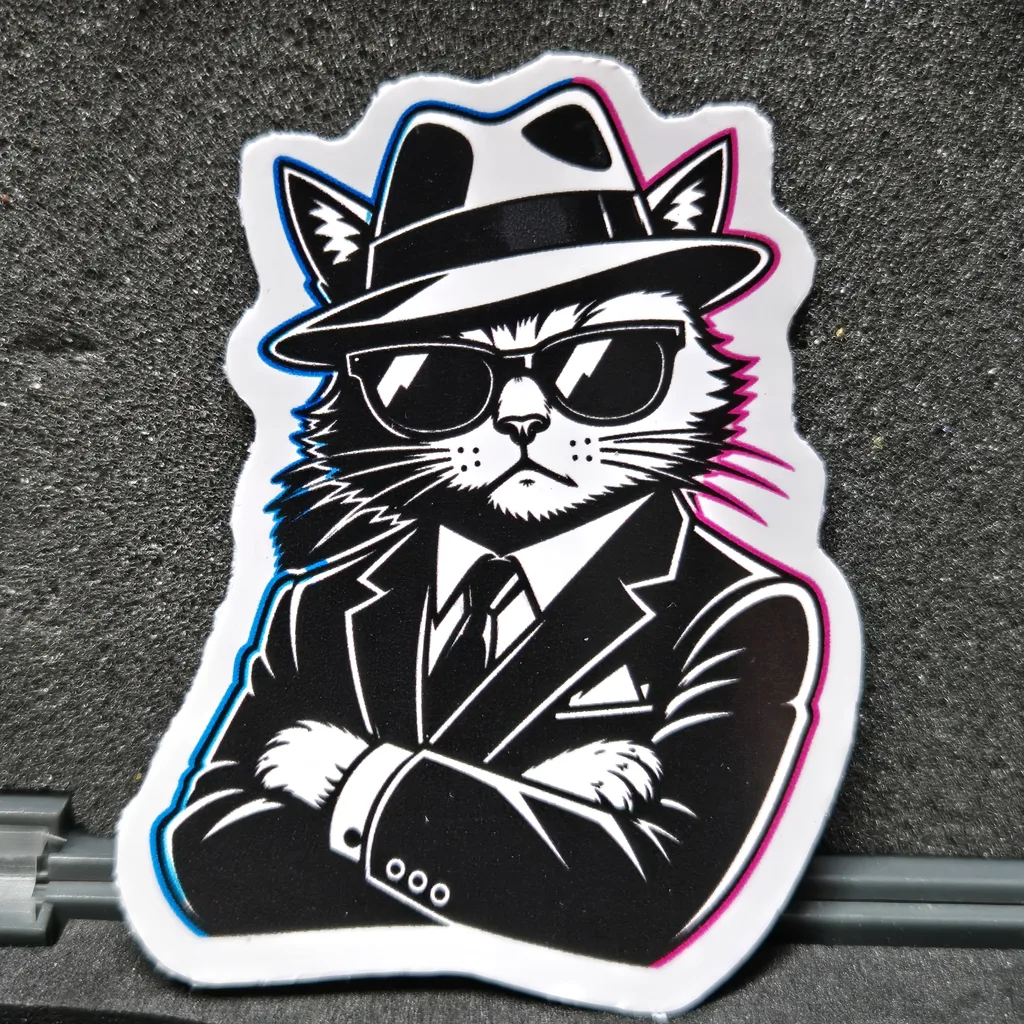 ALPHA CAT die-cut sticker: a cat in a fedora, sunglasses and suit with arms crossed